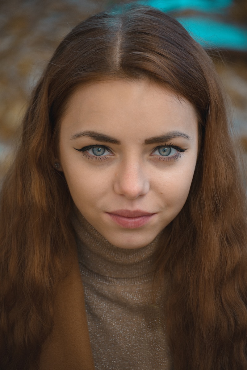 a woman with long brown hair and blue eyes